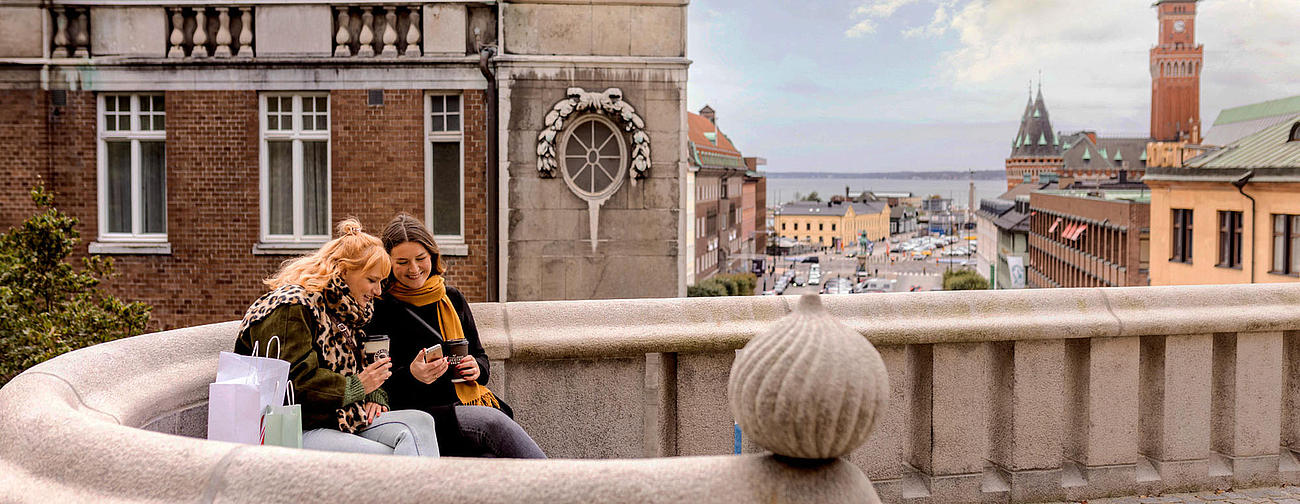 Zwei Frauen sitzen mit Einkaufstüten in Helsingborg. 
