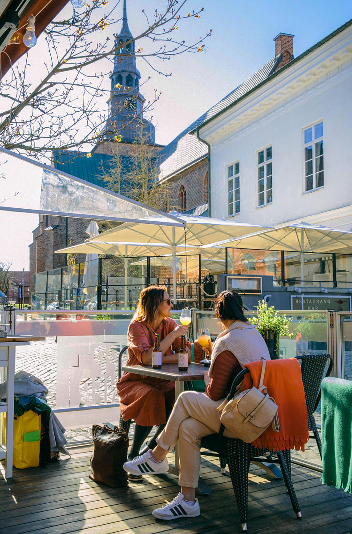 Zwei Personen sitzen im Café mit Blick auf die Marienkirche in Ystad
